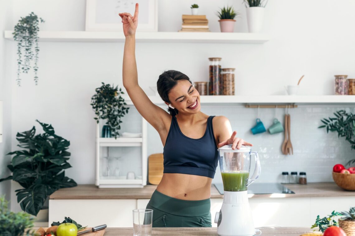 Frau bereitet einen Smoothie mit veganem Protein Pulver zu als Symbol für Plant Protein Lifestyle und moderne High Protein Frühstückstrends.