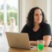 Dreifache Mutter arbeitet flexibel mit Laptop zuhause als Symbol für Nadjas Weg von der Pflegeleitung zu mehr Freiheit mit Mom Business.