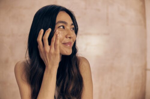 Frau trägt eine leichte Tagespflege auf als Symbol für minimalistische Hautpflege, Underconsumption Core und bewusste Skincare-Routinen.