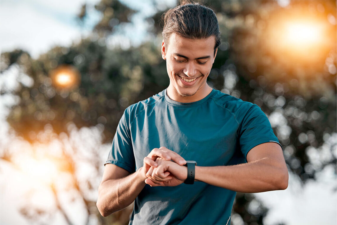Aktiver Mann schaut auf seine Smartwatch als Symbol für Männergesundheit, Vorsorge, Bewegung und bewusste Routinen für ein starkes Leben.