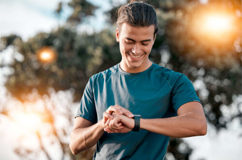 Aktiver Mann schaut auf seine Smartwatch als Symbol für Männergesundheit, Vorsorge, Bewegung und bewusste Routinen für ein starkes Leben.