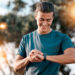 Aktiver Mann schaut auf seine Smartwatch als Symbol für Männergesundheit, Vorsorge, Bewegung und bewusste Routinen für ein starkes Leben.