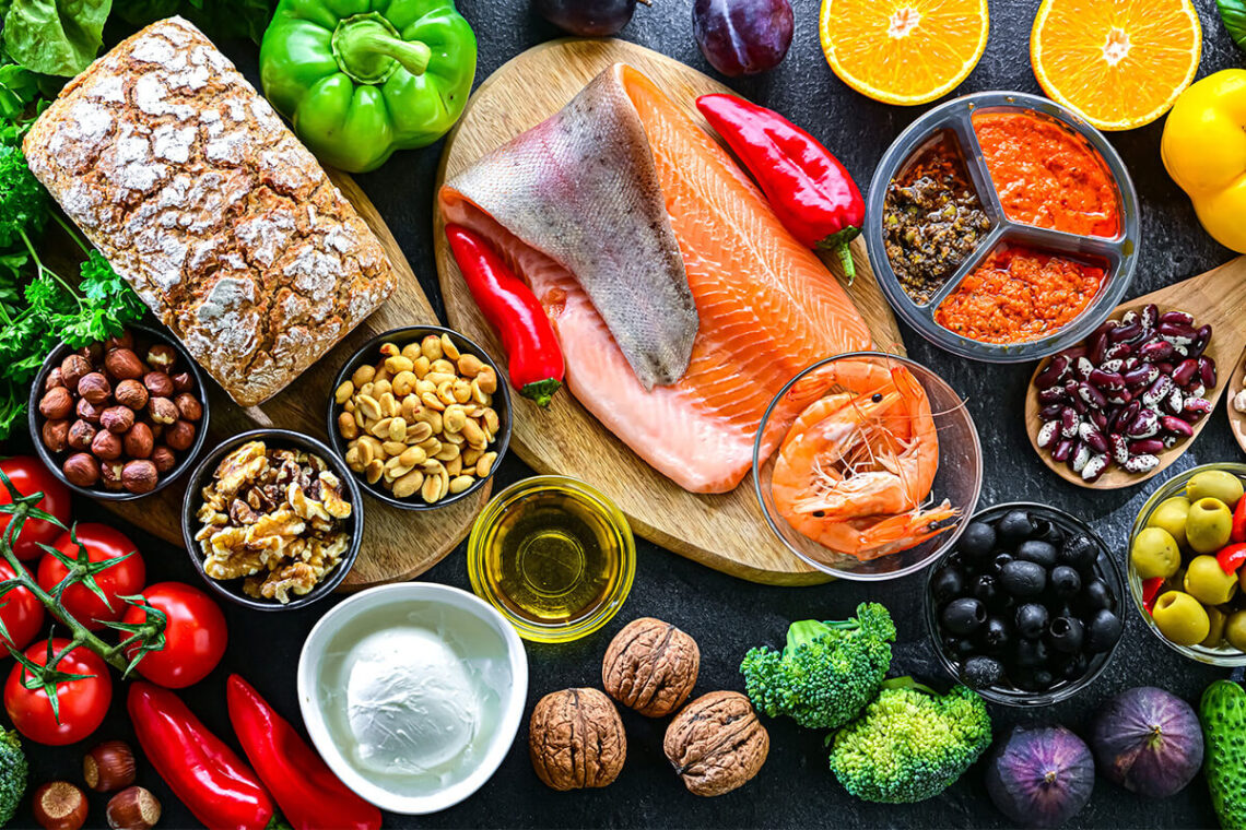 Mediterrane Lebensmittel mit Gemüse, Fisch, Nüssen und gesunden Fetten als Symbol für Low Carb Ernährung und bewusste kohlenhydratarme Küche.