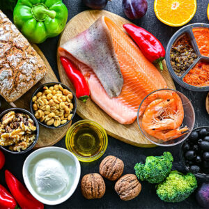 Mediterrane Lebensmittel mit Gemüse, Fisch, Nüssen und gesunden Fetten als Symbol für Low Carb Ernährung und bewusste kohlenhydratarme Küche.